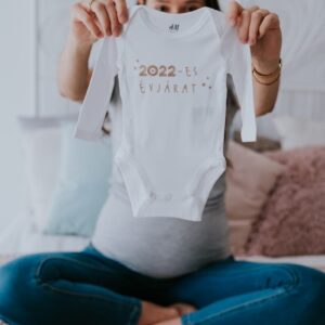 születési évszámos babaköszöntő body kézben tartva