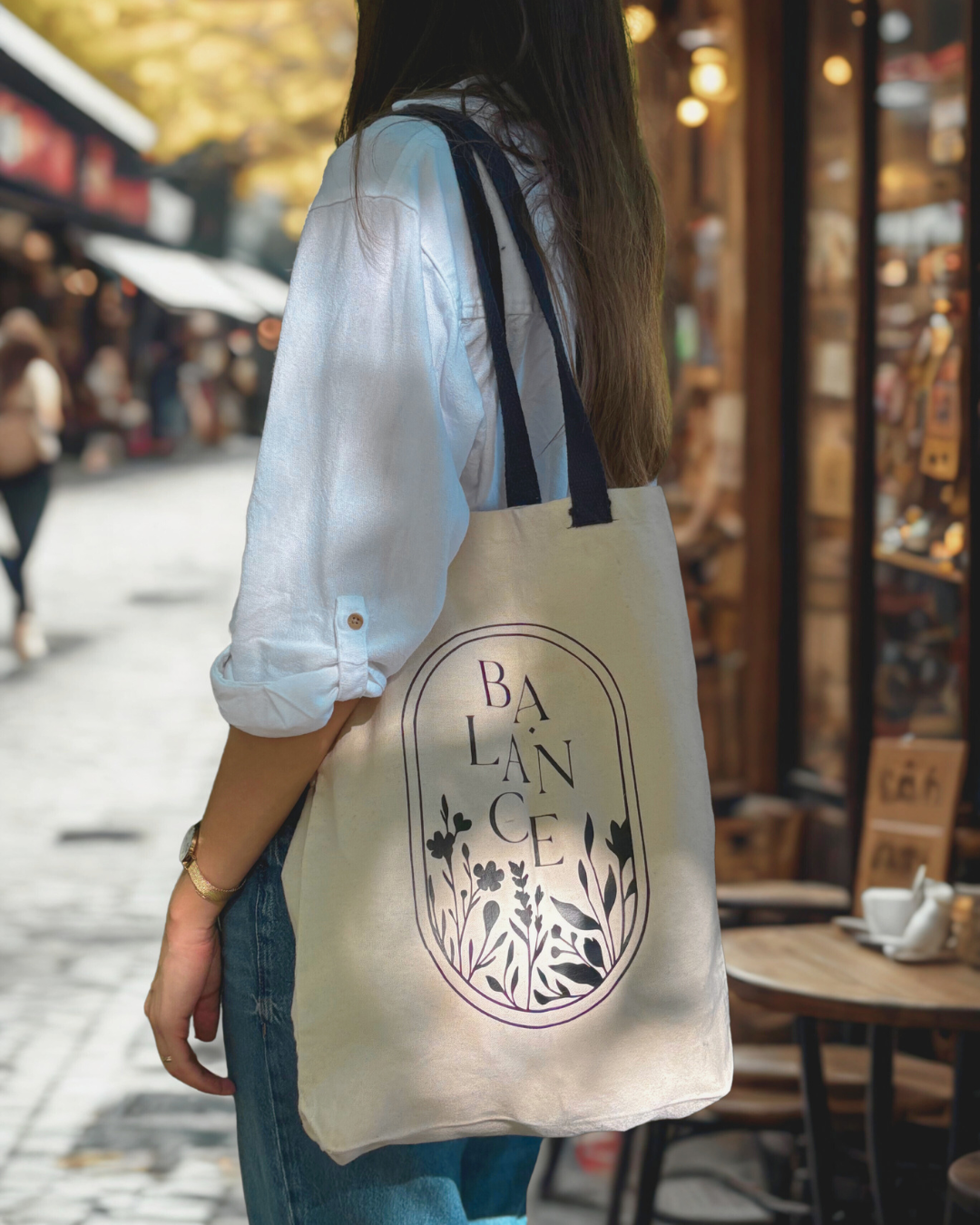 Balance shopper tag vászontáska egy nő vállán kávézó a háttérben