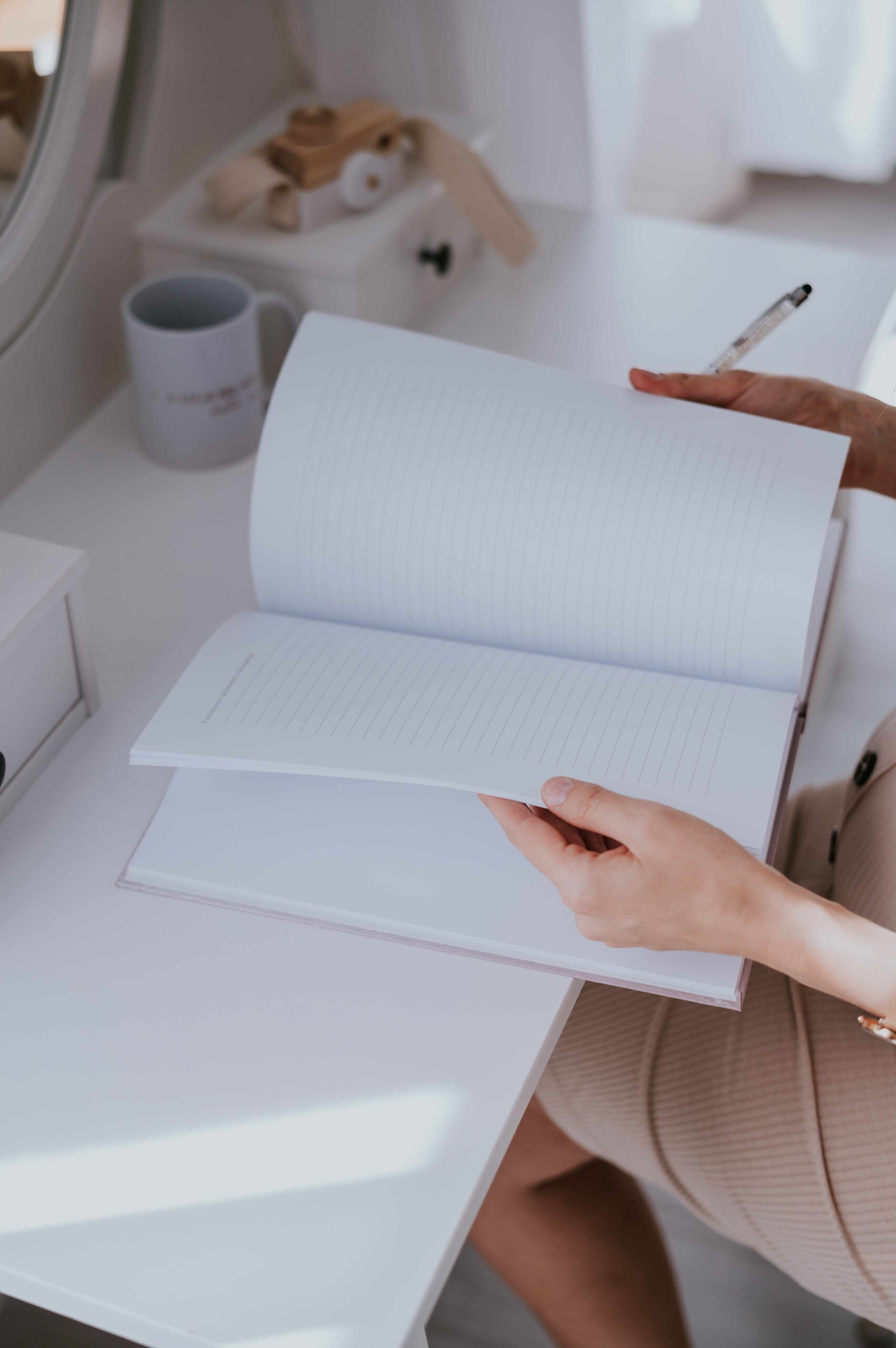 niMin névre szóló babanapló nyitva az asztalon, mellette egy nő aki éppen lapozgatja