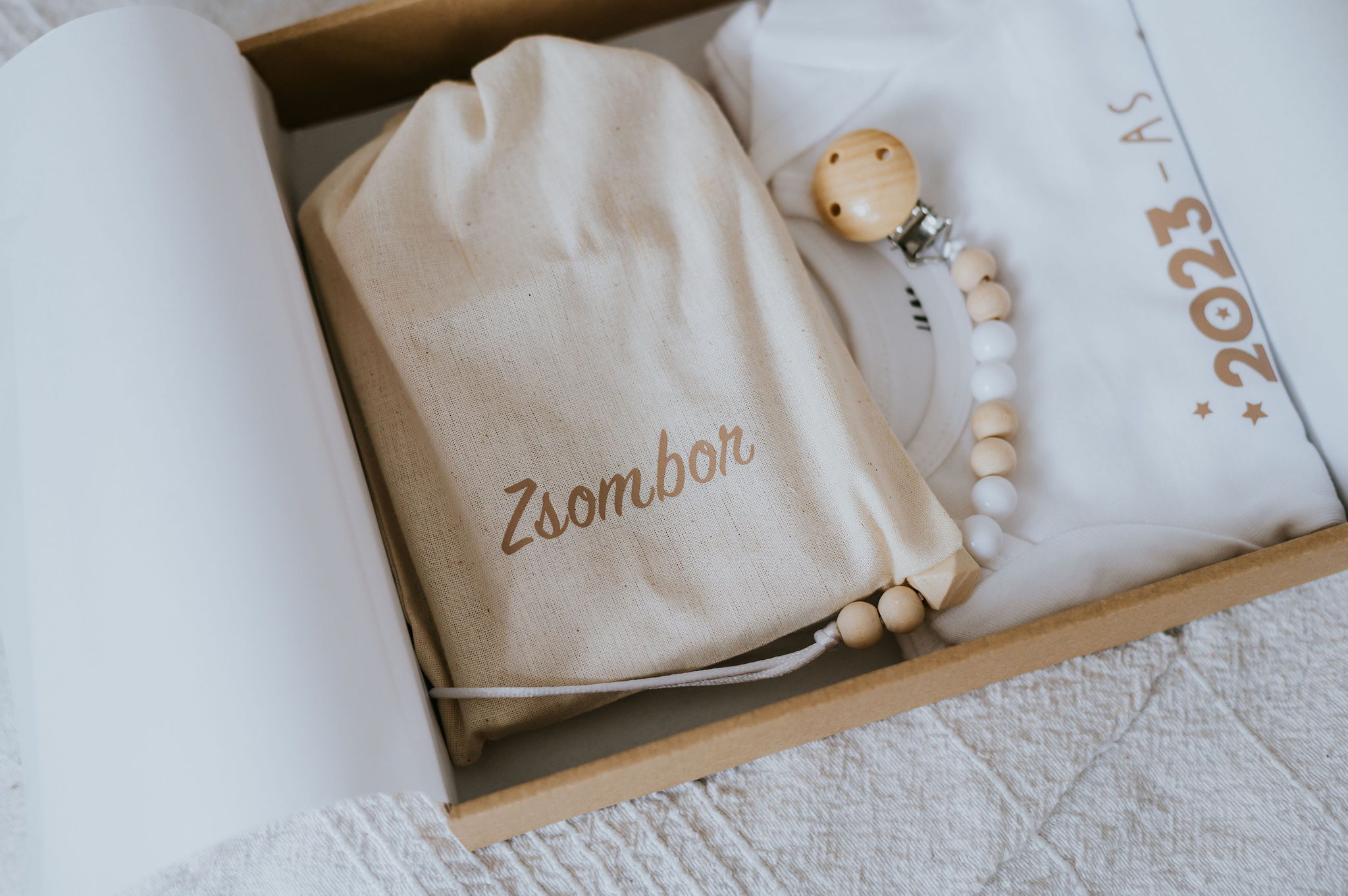 niMin újszülött mérföldkőkártya csomag kisfiú neves szütyőben, fa gumilánc, születési évszámos body ajándékcsomagban